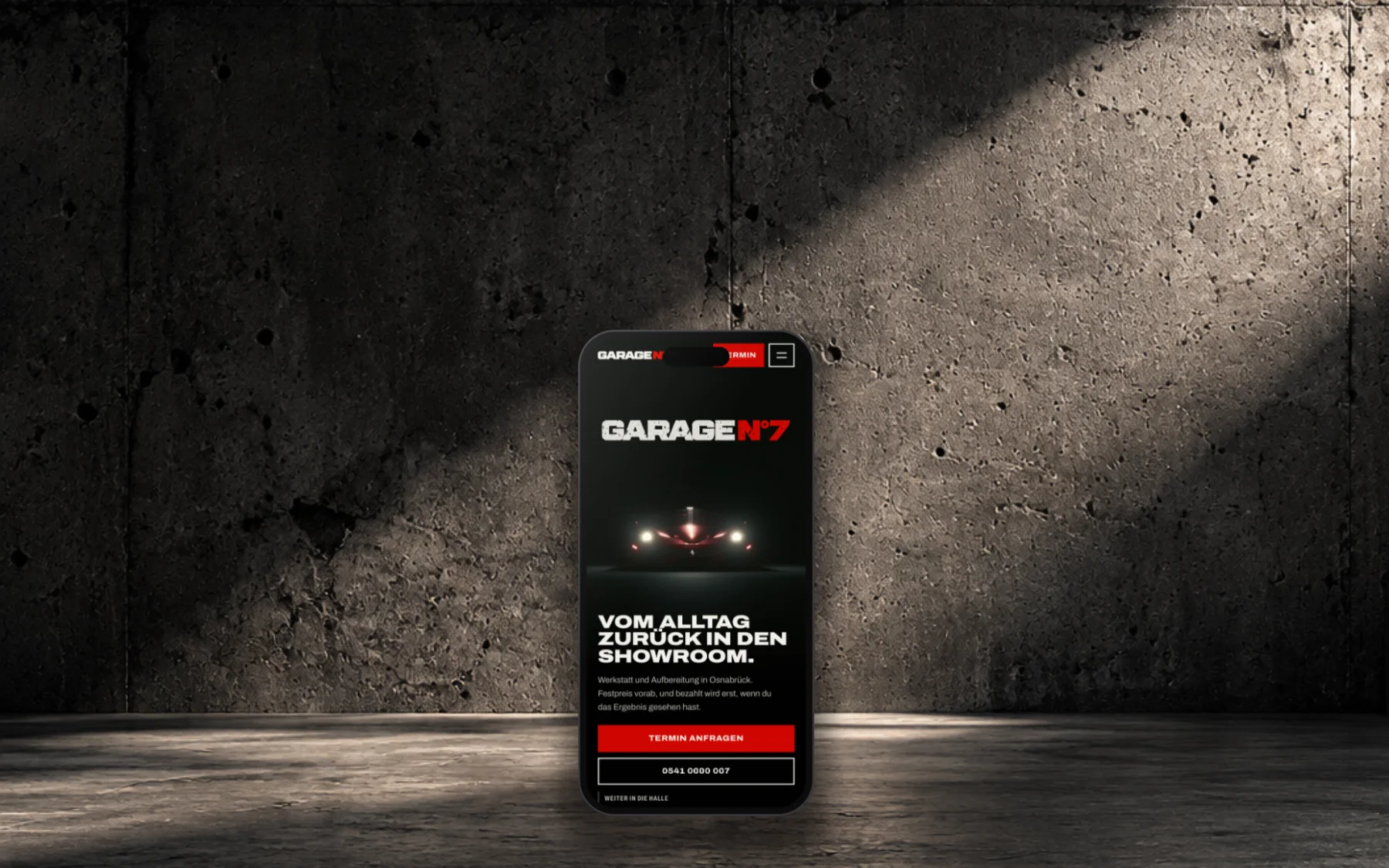 Hand hält ein Smartphone mit der Startseite der Demo Garage N°7